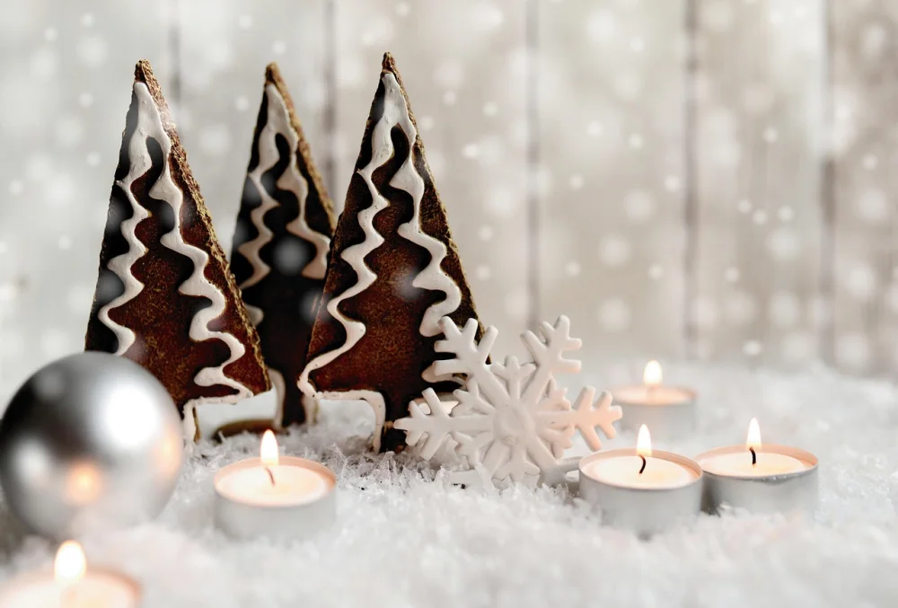 décorer pour noël sans sapin : 15 idées simples pour créer une ambiance festive chez soi 4 trois sapins en biscuit de gingembre décorés de glaçage blanc se dressent au centre, entourés de neige et de bougies chauffe-plat